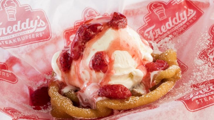 Funnel Cake Sundae from Freddy's Frozen Custard & Steakburgers. Warm funnel cake topped with powdered sugar, vanilla custard, and strawberries.